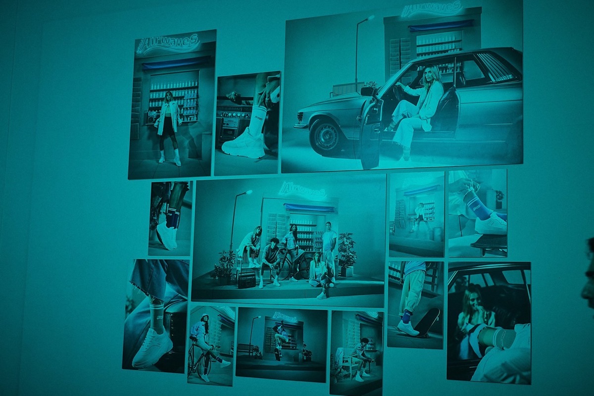 Wand mit den Kampagnenfotos beim Release-Event in Berlin, in türkisem Licht