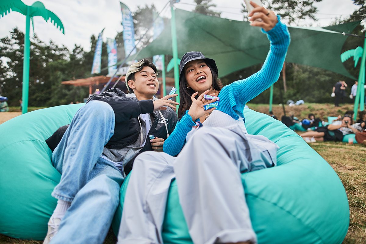 Zwei Festivalgäste machen ein Selfie auf einem mintgrünen Sitzsack