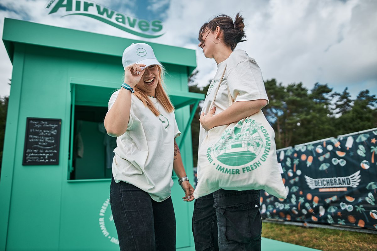 Zwei Frauen mit Airwaves-Tasche und Cap vor dem Kiosk